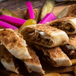 Close-up of delicious shawarma wraps served with vibrant pickled vegetables and crispy fries.