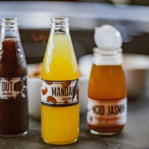 Close-up of vibrant bottled juices with labels on a cafe table, perfect for refreshing moments.